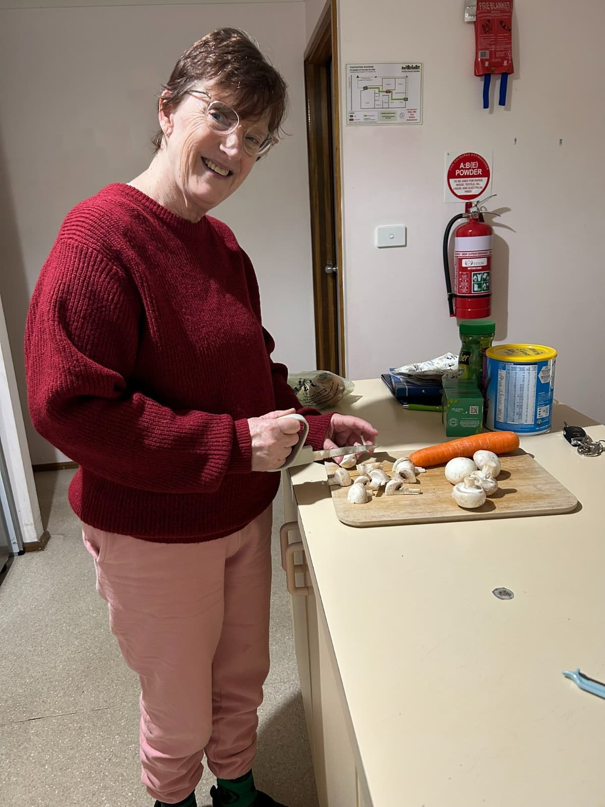 A participant preparing vegetables at the kitchen bench during a cooking session