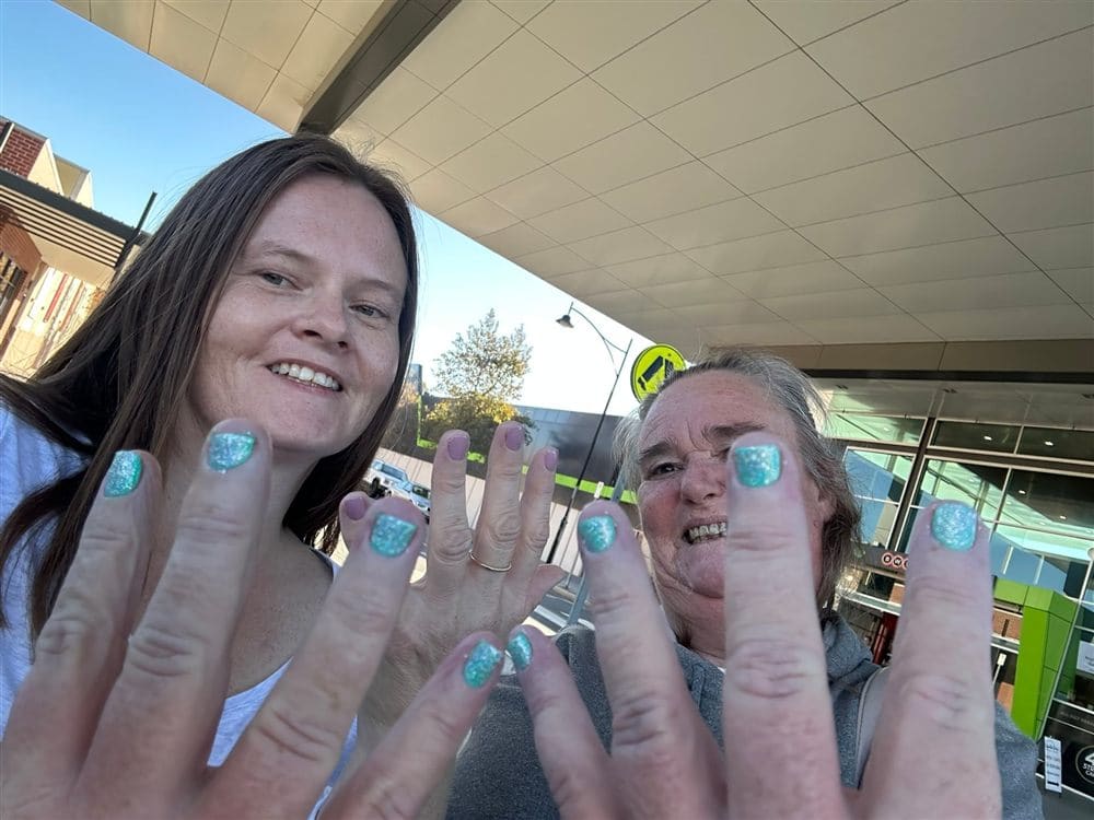Two people showing off their freshly painted nails together
