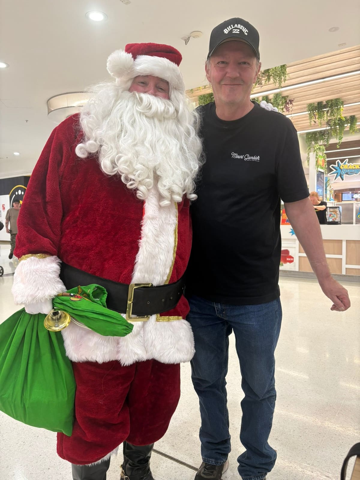 A participant and support worker meeting Santa during a Christmas outing